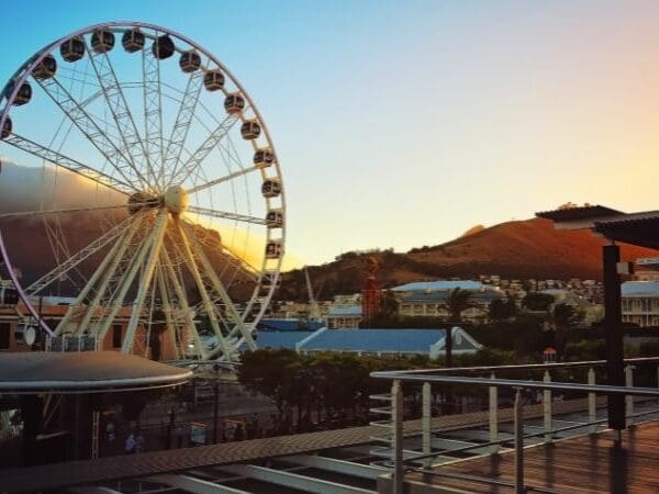 Free things to do in Cape Town - A Ferris wheel in a coastal city at sunset.
