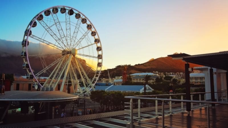 Free things to do in Cape Town - A Ferris wheel in a coastal city at sunset.