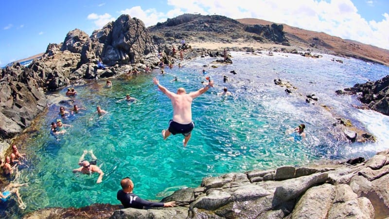 Visitors swimming and diving at Conchi, the natural pool in Arikok National Park.