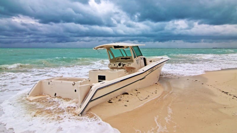 A boat stranded on the sandy shore of Isla Blanca, highlighting Cancun's beautiful beach scenery.