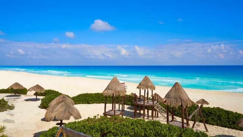 Playa Delfines is known for its scenic views, expansive sandy beach, and colorful Cancun sign.