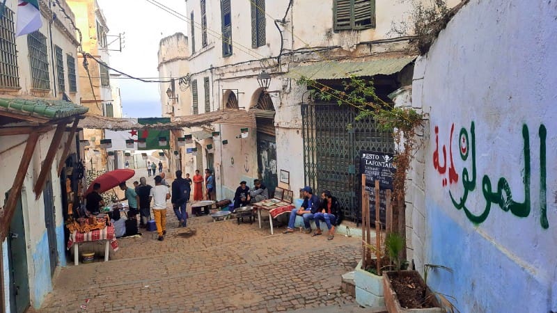 Street vendors and locals in Casbah Algiers, illustrating the vibrant market scene of this UNESCO site.