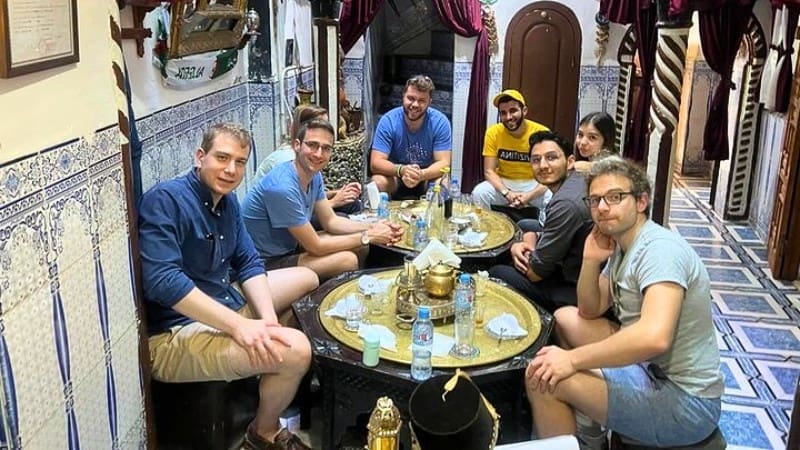 Travelers and tourists resting and enjoying a meal in a traditional café at Casbah of Algiers.