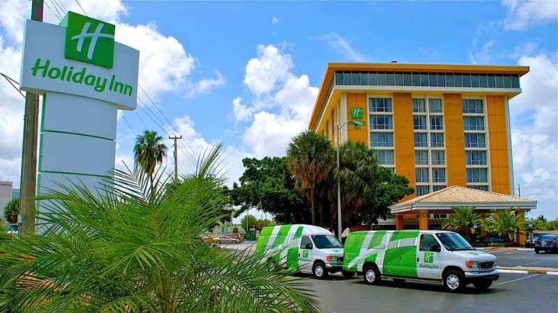 Holiday Inn front view with iconic sign, offering a free shuttle to Miami Cruise Port.