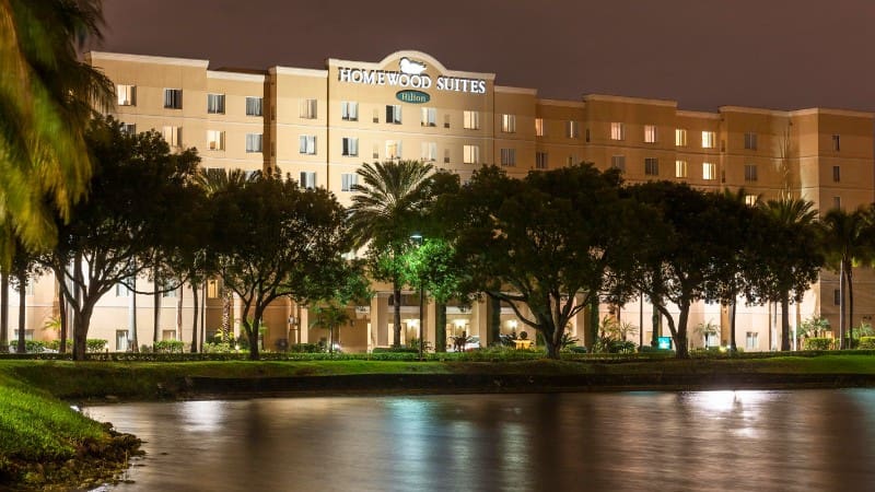 Homewood Suites Brickell lit at dusk, provides shuttles to Miami Cruise Port.