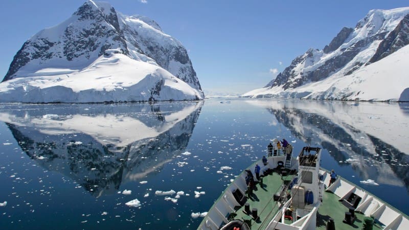 Sail through icy waters aboard a cruise ship, illustrating how to get to Antarctica.