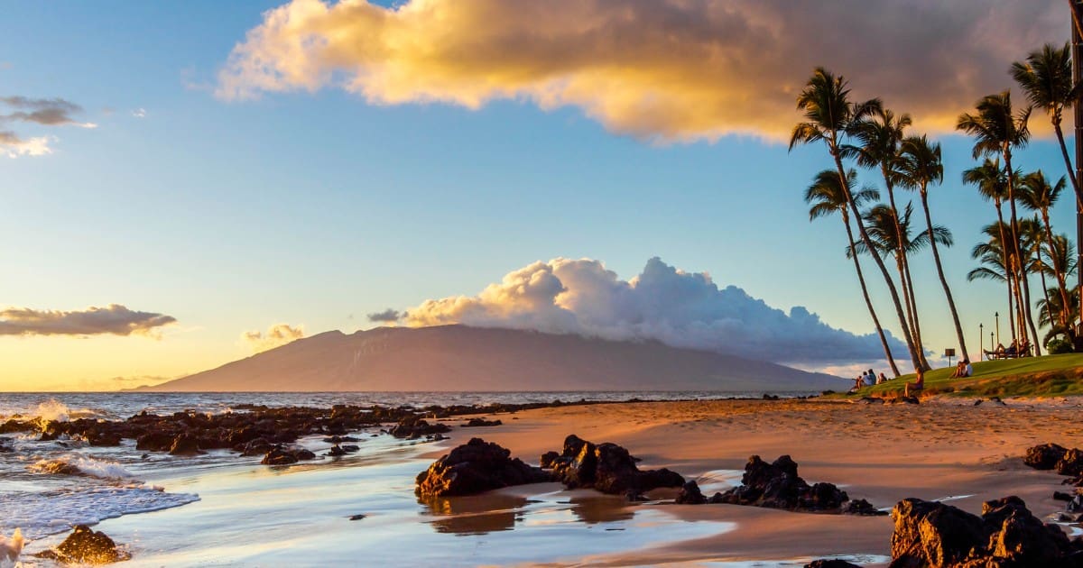 Maui with kids - Stunning sunset with kids playing on the beach, perfect for a family vacation.