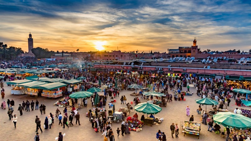 Enjoy Jemaa el-Fnaa, eat and watch shows, a lively spot in Marrakech.