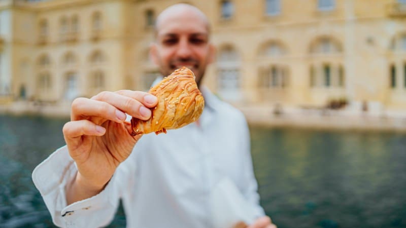 Savoring traditional Maltese pastizzi, a must-try snack when visiting Valletta.