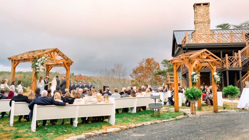 Rustic outdoor wedding at an Alabama venue with wooden pergolas and.