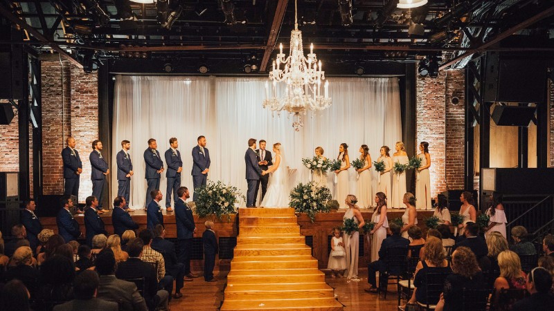 Elegant indoor Alabama wedding venue with chandelier and exposed brick walls.