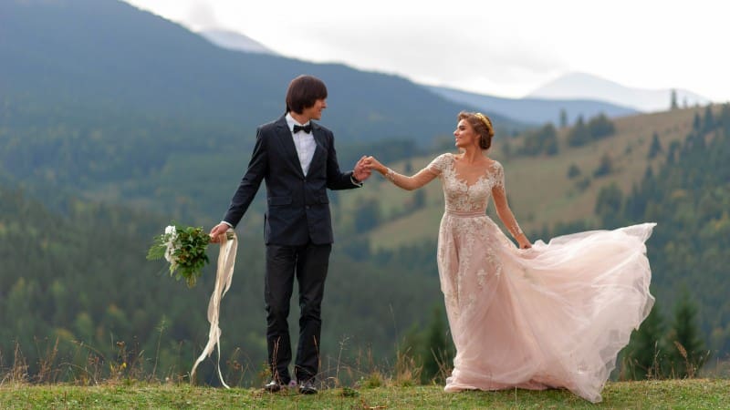 Newlyweds pose against mountain backdrop of Alabama's beautiful wedding locations.