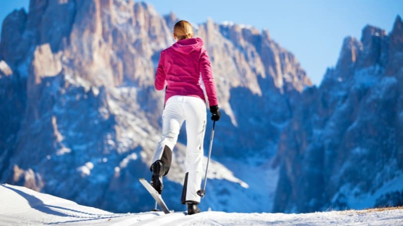 Skier facing dramatic Dolomites vista at Austrian alpine resort.