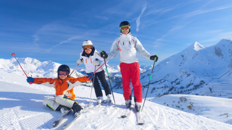 Family skiing together on a sunny day in the Austrian Alps