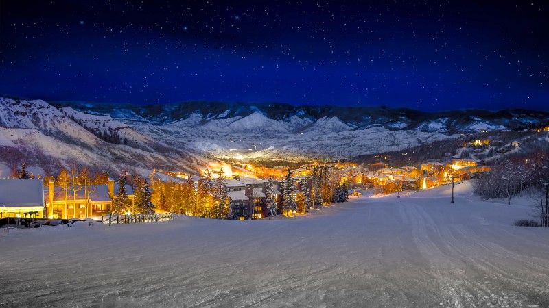 Night skiing in an Austrian mountain village under starry skies