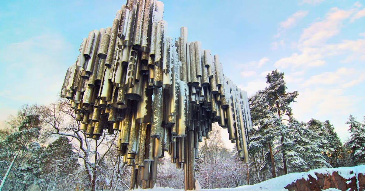 Sibelius Monument in winter, its steel pipes covered in snow against a blue sky.